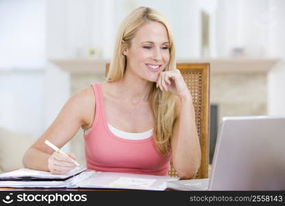 Woman in dining room with laptop smiling