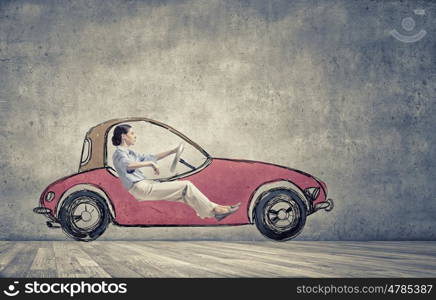 Woman in drawn car. Young humorous woman driving drawn funny car