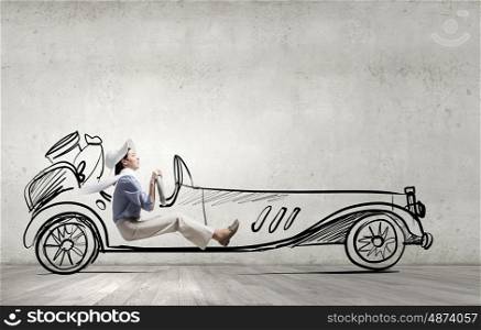 Woman in drawn car. Young humorous woman driving drawn funny car