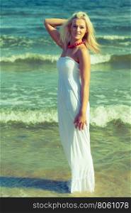 Woman in dress on coast. . Woman in dress on coast. Young lady posing on beach. Outdoor relax leisure concept.