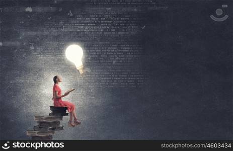 Woman in dress with book. Young girl sitting on stack of books and reading