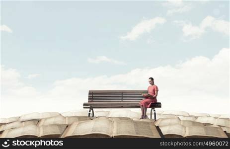 Woman in dress with book. Young woman sitting on bench and reading book
