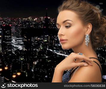 woman in evening dress wearing diamond earrings and ring