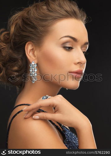 woman in evening dress wearing diamond earrings and ring