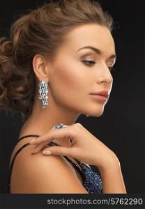 woman in evening dress wearing diamond earrings and ring