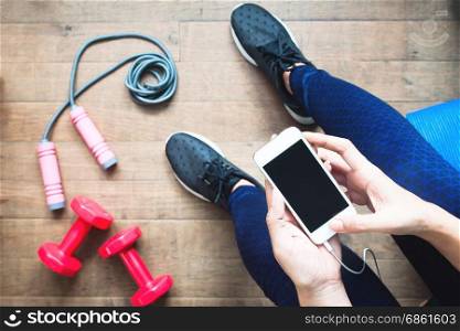 Woman in fitness clothing using smartphone. Fitness and Diet, Healthy Lifestyle concept