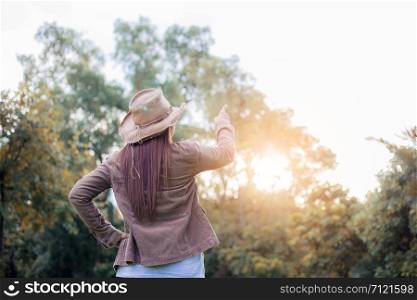 Woman in forest with the sunlight at sky in summer.