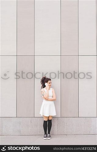 Woman in front of building making telephone call, Milan, Italy