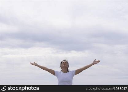 woman in front with white shirt raising her arms to the sky