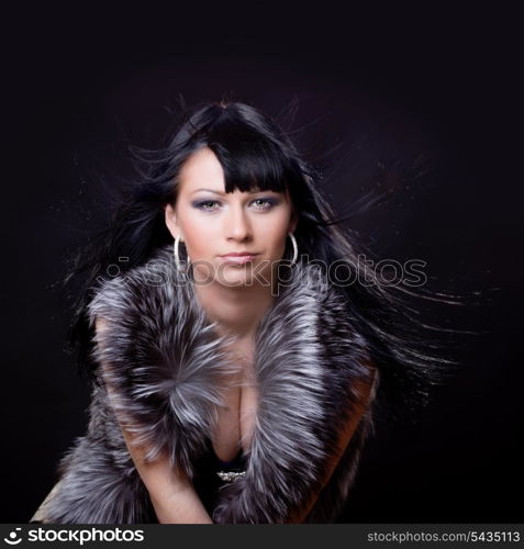 Woman in fur coat on black backgound