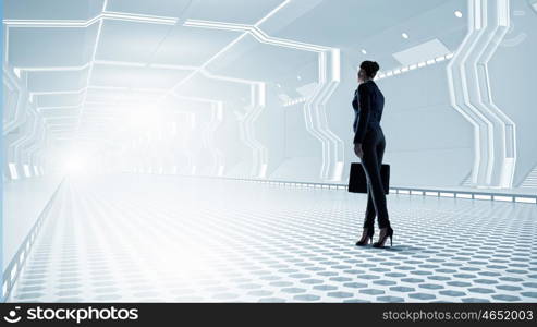 Woman in futuristic interior. Businesswoman standing in virtual designed tunnel room