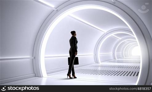 Woman in futuristic interior. Businesswoman standing in virtual designed tunnel room