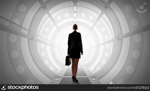 Woman in futuristic interior. Mixed media. Businesswoman standing with back in futuristic designed 3D room