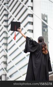 Woman In Graduation Gown Standing Against Building In City