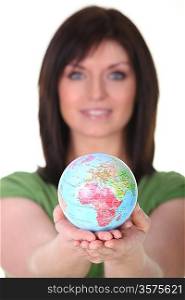 Woman in green holding planet earth