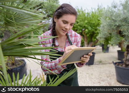 woman in greenhouse writing on a board