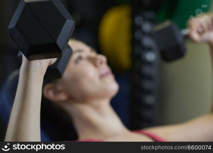 Woman In Gym Exercising With Weights