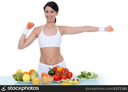 Woman in gym-wear stood with vegetables
