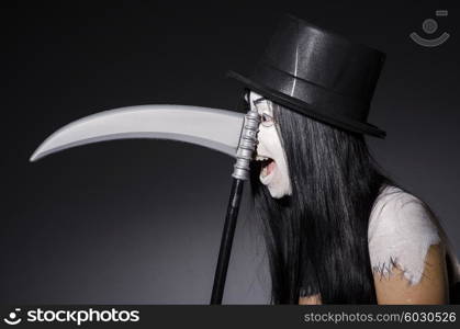 Woman in halloween concept with scythe