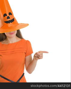 Woman in Halloween hat over eyes pointing on copy space