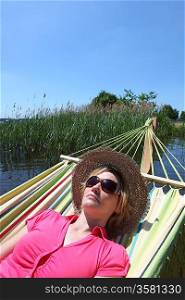 Woman in hammock by lake
