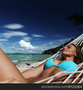 Woman in hammock on beach. Beautiful woman resting in hammock on tropical beach of Thailand