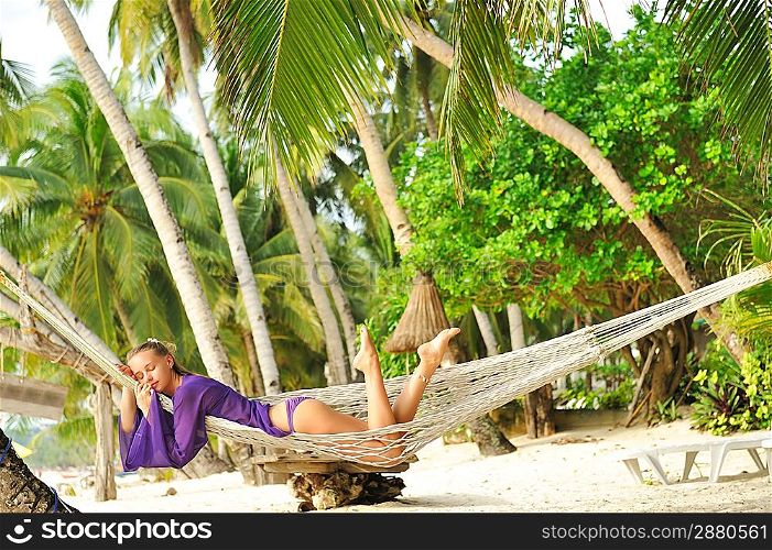 Woman in hammock on tropical beach