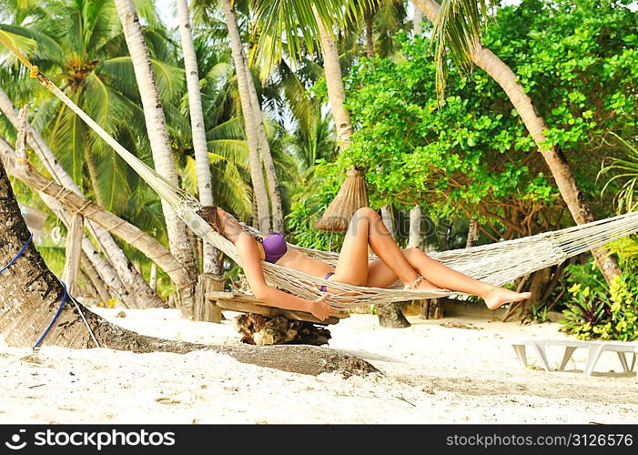 Woman in hammock on tropical beach