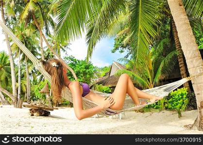 Woman in hammock on tropical beach