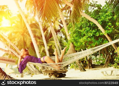 Woman in hammock on tropical beach