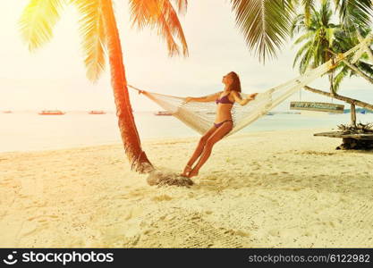 Woman in hammock on tropical beach