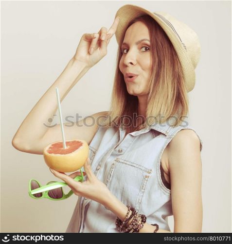 Woman in hat drinking grapefruit juice. Diet. Woman tourist in straw hat drinking grapefruit juice and holding sunglasses. Healthy diet food. Weight loss. Summer vacation holidays.