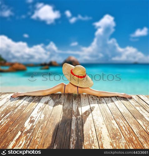 Woman in hat relaxing at beach jetty