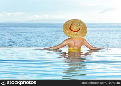 Woman in hat relaxing at the pool