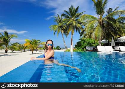 Woman in hat relaxing at the pool