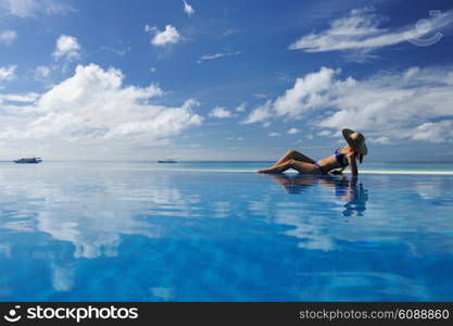 Woman in hat relaxing at the pool