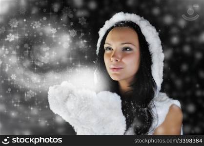Woman in hat smiles and holding a magic gift on a dark background