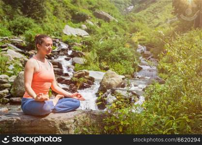 Woman in Hatha yoga asana Padmasana lotus pose outdoors. Woman in Padmasana outdoors