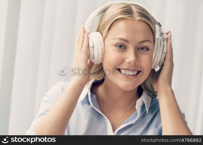 Woman in headphones sitting at desk in office