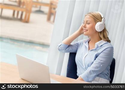 Woman in headphones sitting at desk in office