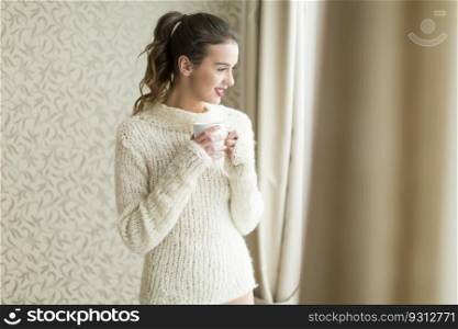 Woman in her sweater holding a cup