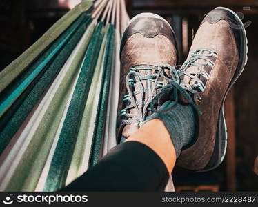 woman in hiking shoes relaxing in hammock after trekking