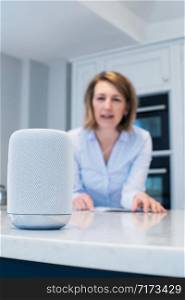 Woman In Kitchen Asking Digital Assistant Question