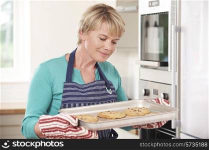 Woman In Kitchen Holding Tray With Home Baked Cookies