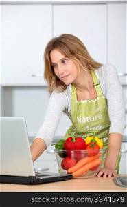 Woman in kitchen looking for cooking receipe