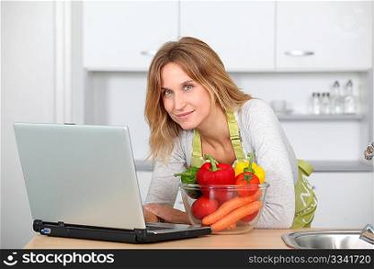 Woman in kitchen looking for cooking receipe