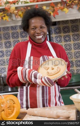 Woman in kitchen making Halloween treats and smiling