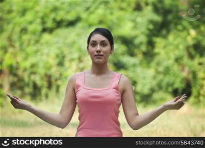 Woman in lawn practicing yoga and looking away