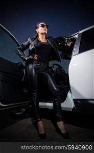 Woman in leather clothes with car