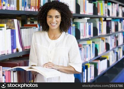 Woman in library holding book (depth of field)